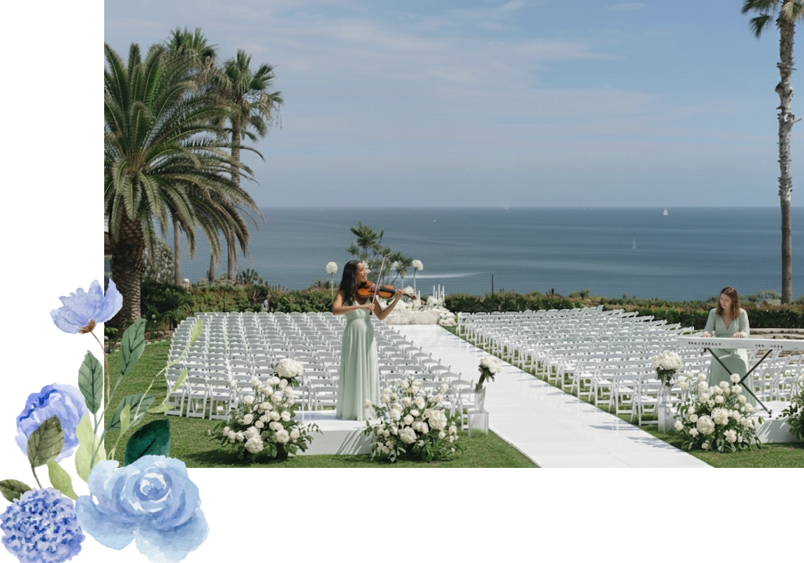 Elegant outdoor wedding ceremony setup by the ocean with a bride walking down the aisle.